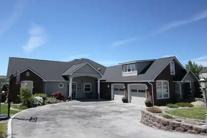 Front of a large single-story house with a three-car garage and a curved driveway