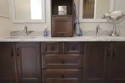 Double sink vanity with a white stone top and dark wood drawers
