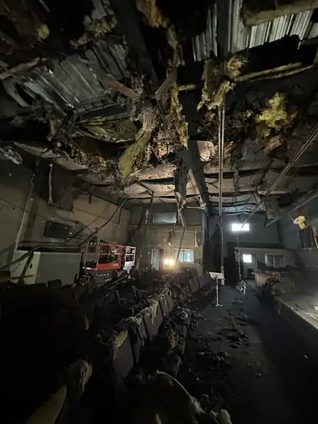 A fire-gutted building interior stripped back to charred framing