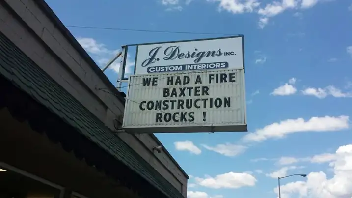 Reader board outside J Designs Custom Interiors reading WE HAD A FIRE, BAXTER CONSTRUCTION ROCKS!