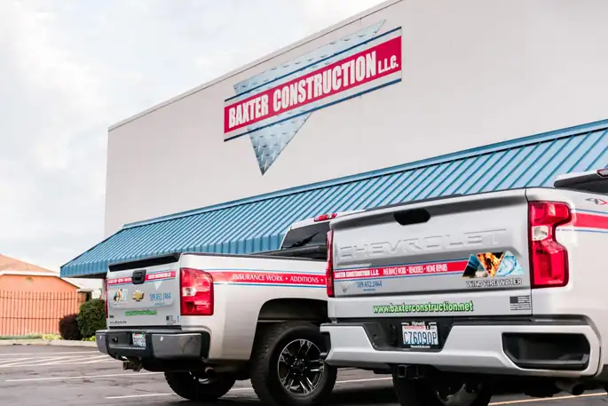 The BAXTER CONSTRUCTION L.L.C. sign and branded white pickups out front of the River Rd building in Yakima