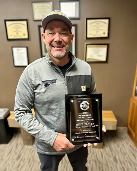 Brice Baxter holding a Remodeler of the Year plaque in the office